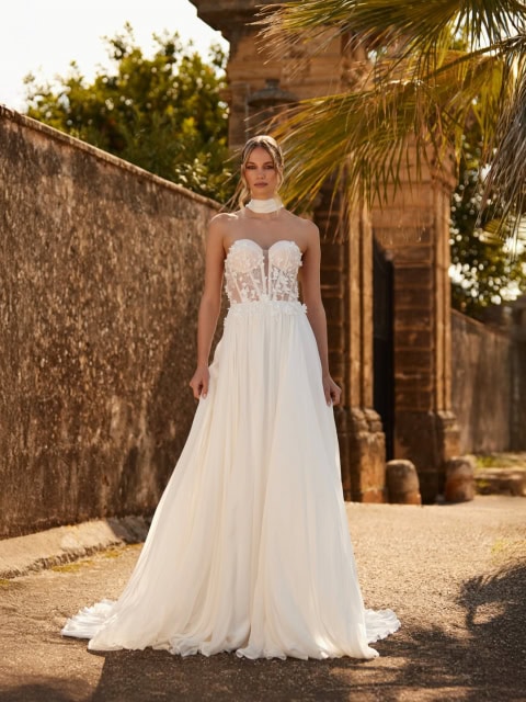 🤍 Das Oberteil aus feinem Tüll-Lingerie mit floralen Spitzenelementen geht sanft in einen leichten Rock aus Seidenchiffon über und verleiht dem Kleid eine zarte, ätherische Ausstrahlung.