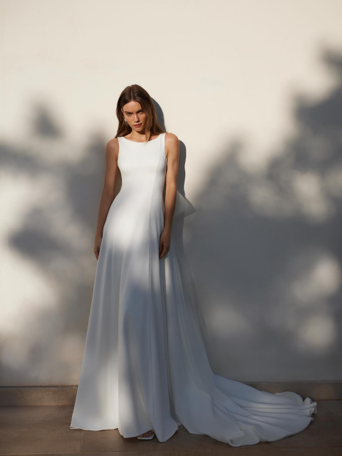 NEW COLLECTION 

Dieses Brautkleid ist der Inbegriff modernen Minimalismus - klare Linien, fließende Bewegungen und elegante Raffinesse.

Eine glatte, figurbetonte Passform am Oberteil, während der Rock in einer weichen, luftigen A-Linien-Silhouette fällt.