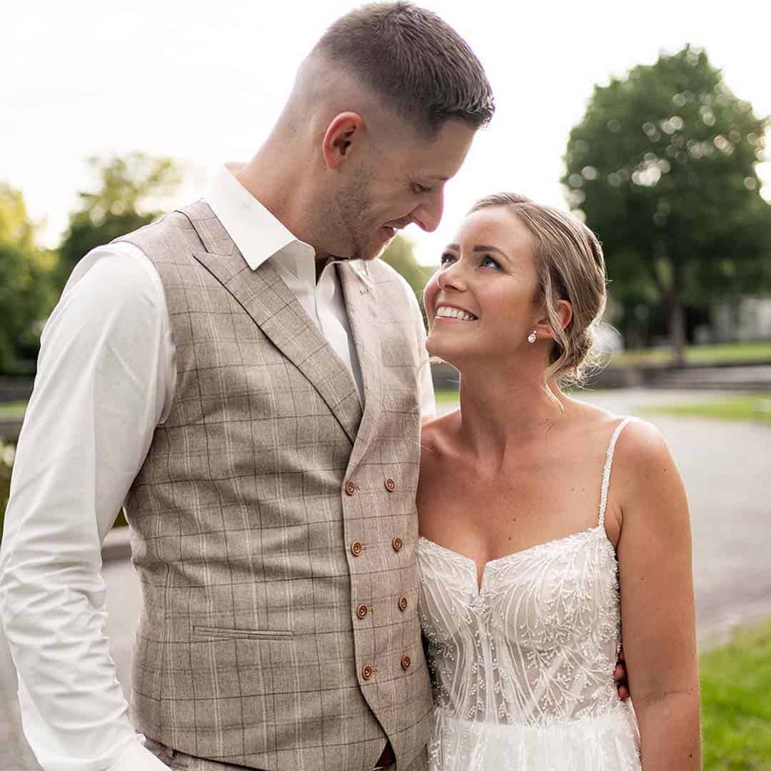 Sandy Hochzeit Kurgarten Elegantes Brautpaar in Hochzeitsoutfits, verliebt und glücklich, draußen vor malerischer Kulisse, perfekte Stimmung für Hochzeitsfotografie, Brautkleid und prächtiger Anzug.